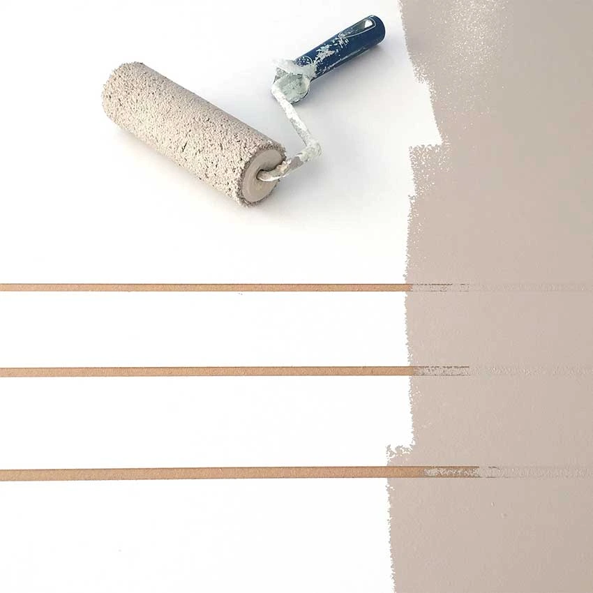 Application de peinture colorée sur une boiserie au rouleau.